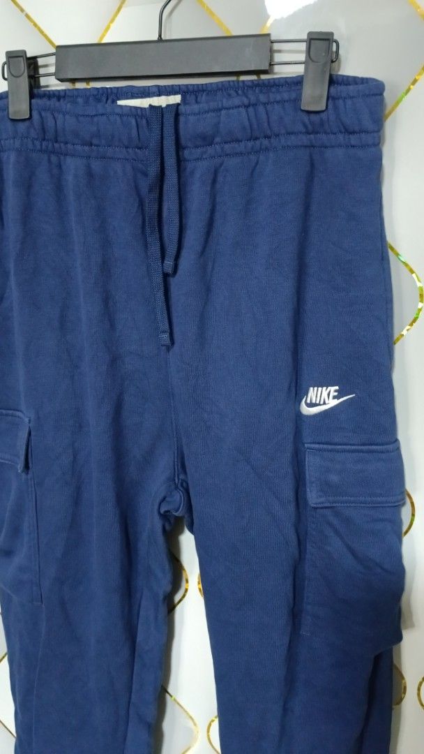 Nike Blue Cargo Sweatpants (Category: Joggers) located in Manila. Submitted by zariyah.1986 (Listing ID 1470795110, Image 2). Description: - Brand: Nike - Style: Cargo sweatpants with utility pockets on both legs - Color: Blue with embroidered white Nike logo on the left thigh - Size: L (Product code: CZ9955-410) - Features: Adjustable drawstring waistband and elastic ankle cuffs - Origin: Made in China - Condition: Great for casual wear and dail