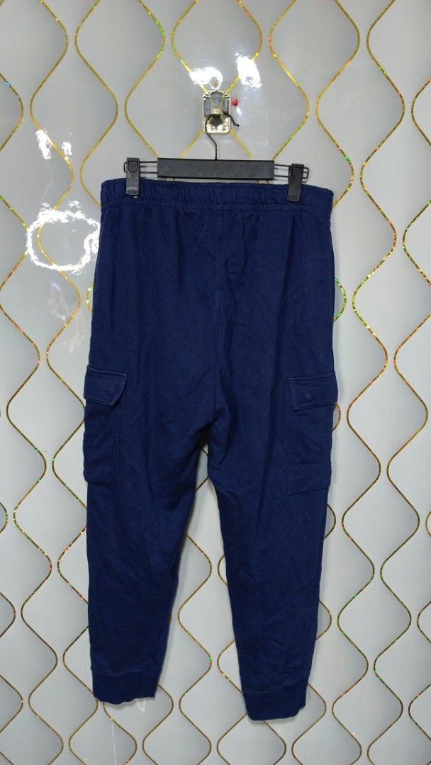 Nike Blue Cargo Sweatpants (Category: Joggers) located in Manila. Submitted by zariyah.1986 (Listing ID 1470795110, Image 3). Description: - Brand: Nike - Style: Cargo sweatpants with utility pockets on both legs - Color: Blue with embroidered white Nike logo on the left thigh - Size: L (Product code: CZ9955-410) - Features: Adjustable drawstring waistband and elastic ankle cuffs - Origin: Made in China - Condition: Great for casual wear and dail
