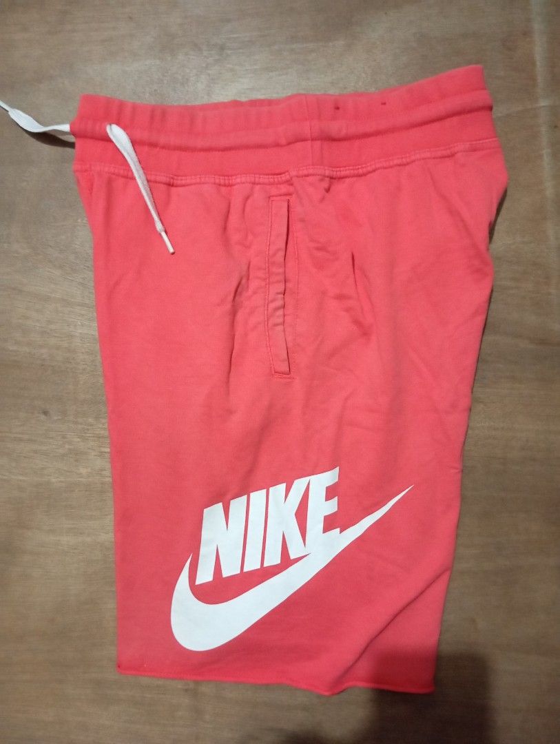 Nike Coral Sweat Shorts Size M (Category: Shorts) located in Muntinlupa City. Submitted by thriftsmuntinlupa26 (Listing ID 1470877824, Image 2). Description: - Brand: Nike - Color: Bright coral - Size: M (approx. 20 inches total length) - Details: Large white logo on left leg, elastic waistband with white drawstring cords, two side pockets - Condition: Great casual wear piece - Origin: Made in China.