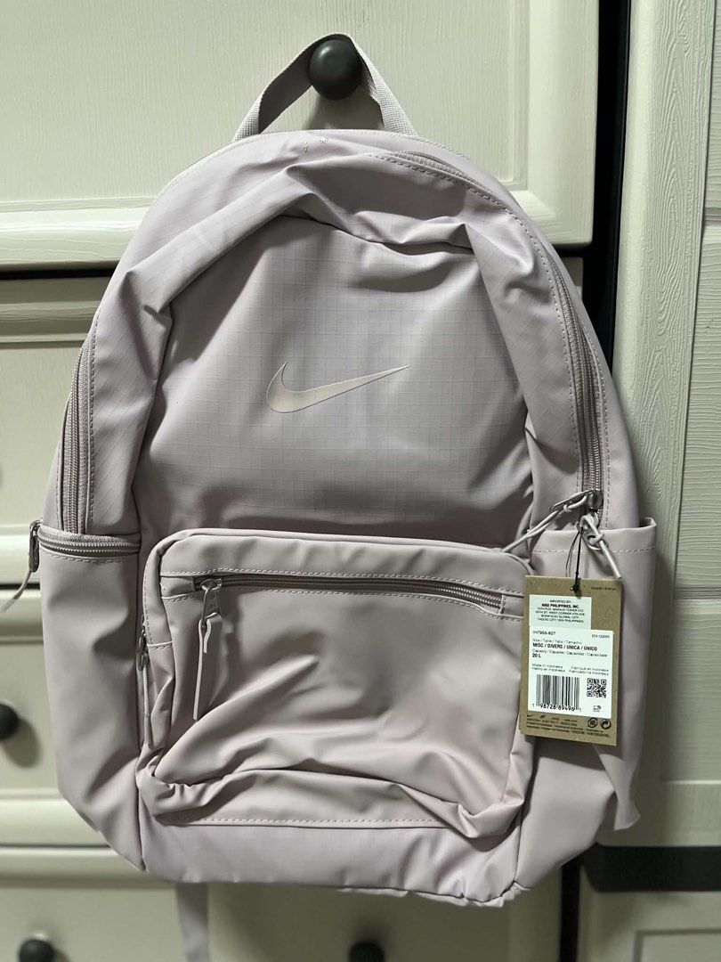 Nike Eugene Winterized Pink Grid Backpack 20L (Category: Backpacks) located in Caloocan City. Submitted by sarahastrid (Listing ID 1470866278, Image 1). Description: - Brand: Nike - Capacity: 20L - Color/Design: Pale pink with grid pattern - Condition: Brand new with original tag attached - Compartments: Front zippered compartment, main zipped section with inner slip pocket, and side pockets - Comfort: Padded mesh shoulder straps and back panel -