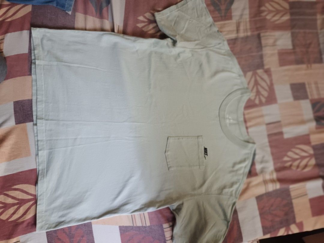 Nike pocket tee shirt (Category: Activewear) located in Odiongan. Submitted by thriftngo26 (Listing ID 1470759008, Image 1). Description: This item is the Nike Sportswear Premium Essentials Pocket T-Shirt in the "Seafoam" / "Jade Aura" colorway (Style Code: DQ9295-017 / FN3705-017). It is a heavyweight cotton tee featuring a roomy, loose fit and a signature chest pocket that partially covers the embroidered Nike Futura logo..