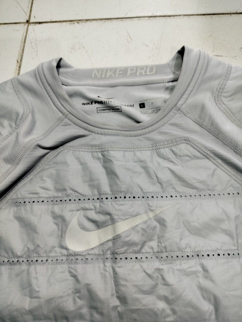 Nike Pro Hyperwarm Compression Shirt Grey Size L (Category: Activewear) located in Manila. Submitted by geraldquinto_917 (Listing ID 1470878462, Image 2). Description: - Brand: Nike Pro - Model: Hyperwarm Compression Long Sleeve Shirt (Style Code: 826699-012) - Color: Grey - Size: Large (L) - Features: Padded quilted chest and shoulder panels with ventilation perforations, Nike Pro branded elastic waistband collar and hem tag - Best for: Cold wea