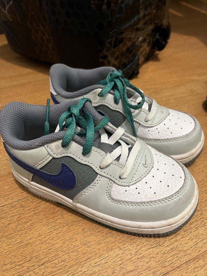Nike Toddler Air Force 1 Low (Category: Babies & Kids Fashion) located in Dasmarinas. Submitted by casabthebrand (Listing ID 1470748519, Image 1). Description: Nike toddler sneakers in light grey, white, and blue. Green laces installed with extra white laces included in the box. Size US 8C, UK 7.5, EUR 25. Style code FJ8788-001. Clean soles with minimal wear. Great everyday shoes for little ones..