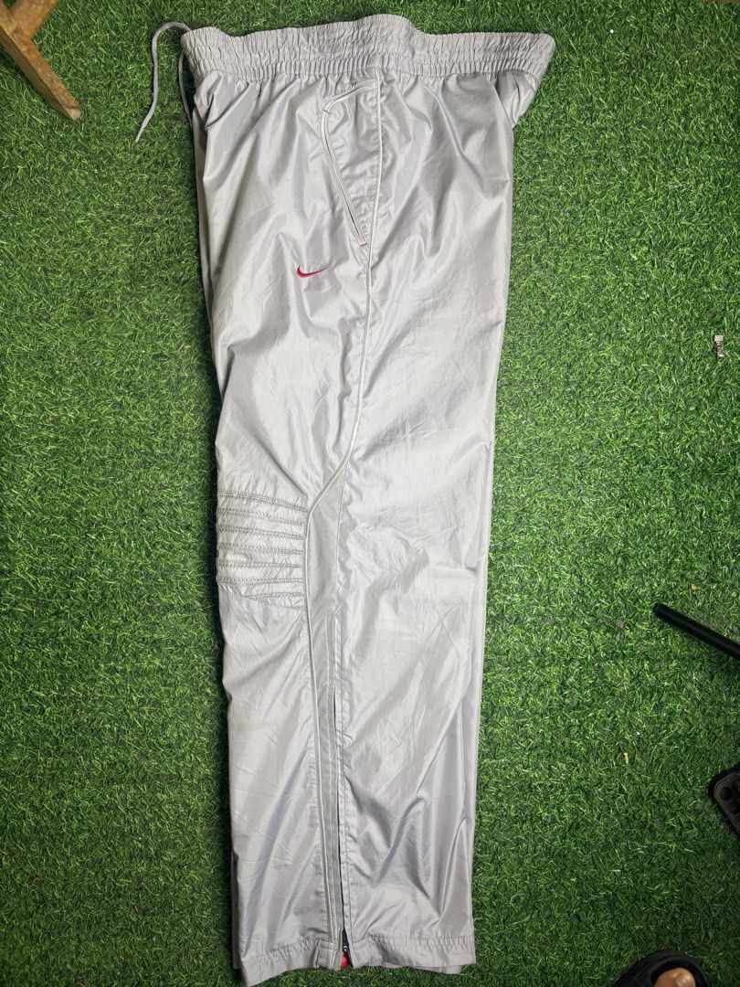 Nike track Pant (Category: Trousers) located in Manila. Submitted by josh2295 (Listing ID 1470764450, Image 3). Description: vintage Y2K-era Nike grey nylon track pants featuring an embroidered red Swoosh logo and panel detailing. W:38-40 L:41 LH:10.