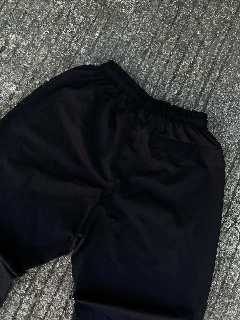 Nike Woven Nylon Pants For Men(29-33x28) (Category: Joggers) located in Lianga. Submitted by arwthrifts (Listing ID 1470844366, Image 3). Description: - Brand: Nike - Color: Classic Black with white embroidered logo - Pockets: Secure zippered side pockets - Waistband: Elastic with matching black drawstrings - Cuffs: Elastic ankle cuffs for a tailored fit - Condition: Excellent, clean stitching and solid fabric.