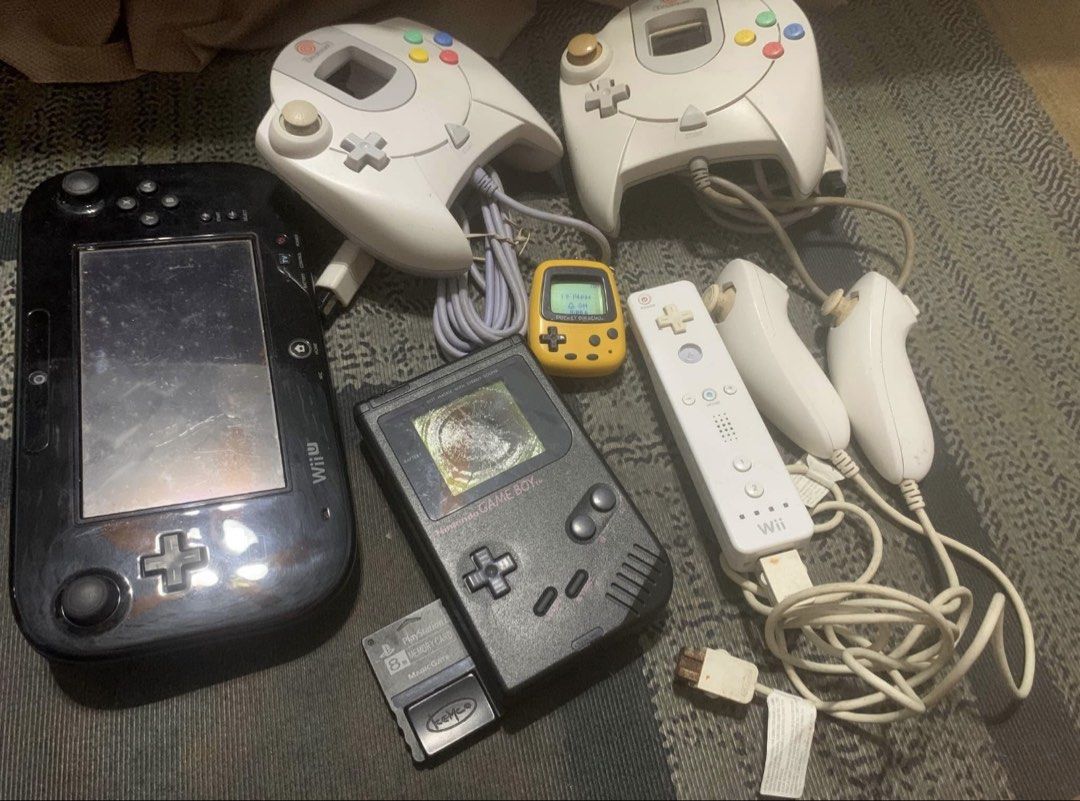Nintendo Assorted Items (Category: Nintendo) located in Manila. Submitted by thriftstoress (Listing ID 1470746075, Image 1). Description: - Retro Gaming Lot: Includes black Wii U gamepad, original Game Boy with PS memory card, yellow Pocket Pikachu, 2 Sega Dreamcast controllers, 1 Wii remote, and 2 nunchuks - Condition: Heavy signs of use, scuffs, scratches, and wear across all items; cords are tangled - Ideal For: Retro collectors looking for a 