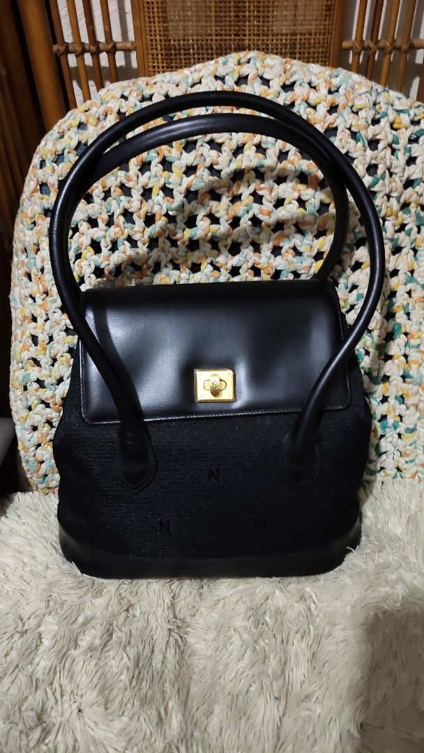 Nobuo collection...Black structured shoulder bag with gold turn-lock closure (Category: Shoulder Bags) located in Cebu City. Submitted by lumaynojes00490 (Listing ID 1470828098, Image 3). Description: - Color: Classic black - Material: Textured fabric body with smooth leather flap and trim - Design: Subtle embroidered 'N' pattern with clean lines - Hardware: Elegant gold-tone square turn-lock closure - Straps: Two long, rounded shoulder straps fo