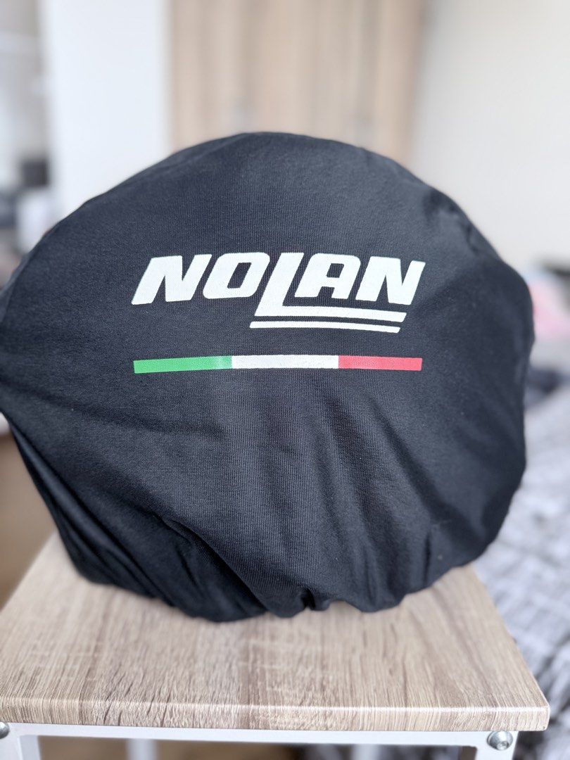 Nolan motorcycle helmet lexan polycarbonate size M (Category: Caps & Hats) located in Pasig City. Submitted by sherill888 (Listing ID 1470795012, Image 1). Description: - Brand/Model: Nolan Full Face Motorcycle Helmet - Design: Bold black, red, and white graphics - Visor: Clear visor currently installed - Condition: Impeccably clean inside and out - Inclusions: Original Nolan black fabric storage bag with Italian flag stripe design - Status: Road