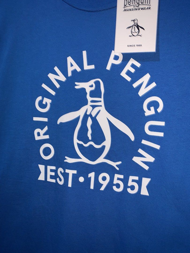 Original Penguin Graphic Tee Blue Size M (Category: Tshirts & Polo Shirts ) located in Tayug. Submitted by cvcthrift (Listing ID 1470895171, Image 2). Description: 21/29 NO ISSUE BNEW CONDI CR-9.5/10 - Brand: Original Penguin by Munsingwear - Condition: Brand new with original retail tags attached - Color: Bright blue - Material: 100% Cotton (Made in El Salvador) - Design: Large white chest graphic with logo and 'EST 1955' text, plus a small bran