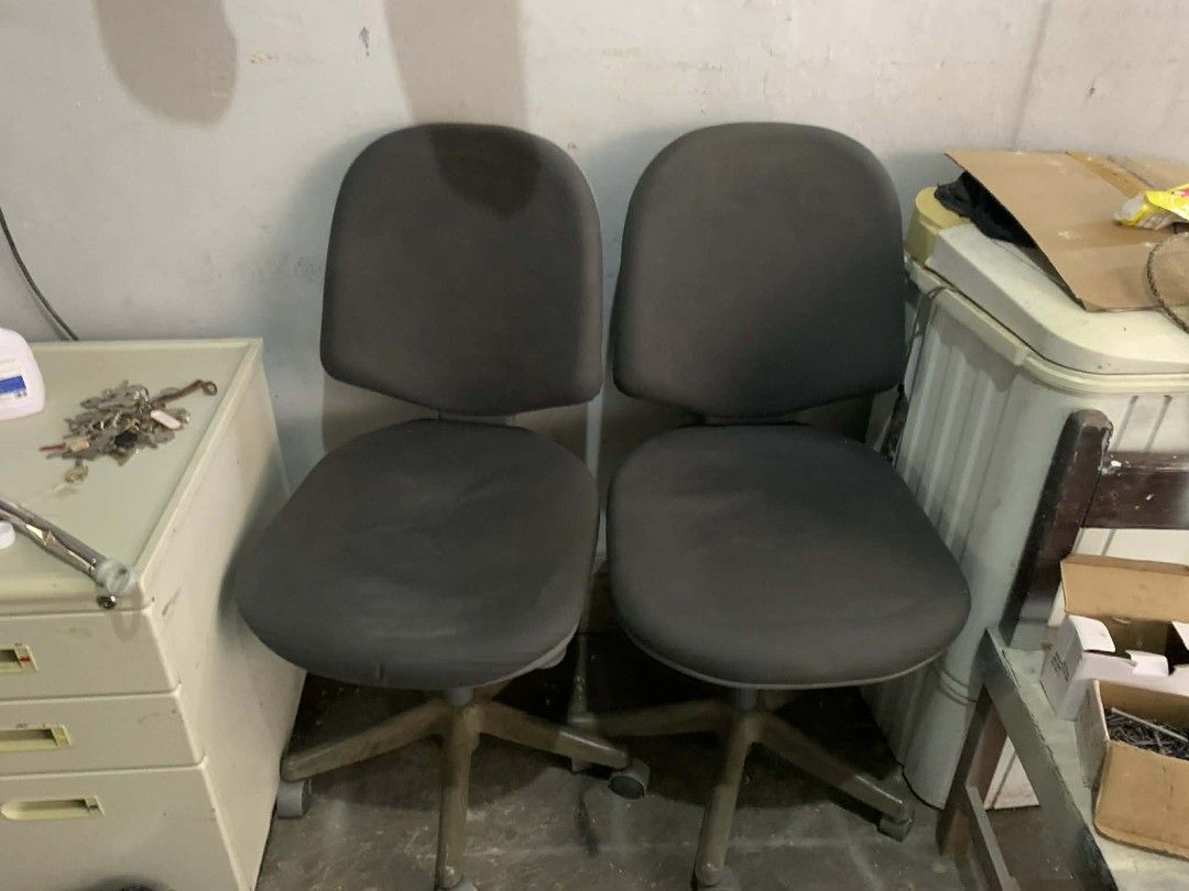 Pair of grey rolling office chairs (Category: Office Furniture & Fixtures) located in Manila. Submitted by cleverocean.10acf9 (Listing ID 1470843598, Image 1). Description: - 2 grey office chairs with padded seats and backs - Standard height adjustment levers and 5-star bases with wheels - Ideal for everyday desk setups or work-from-home tasks - Condition: Shows normal dust and minor wear from being stored in a garage - Selling as-is.