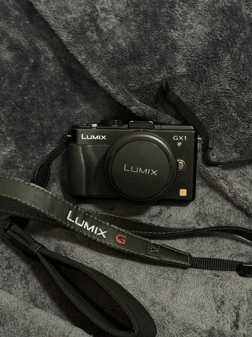 Panasonic Lumix DMC-GX1 Mirrorless Camera with Strap (Category: Cameras) located in Las Pinas. Submitted by myqanorella (Listing ID 1470930543, Image 2). Description: - Model: Panasonic Lumix DMC-GX1 Mirrorless Camera (Black) - LANGUAGE: Japanese (NO BUILT IN LANGUAGE CHANGER) - Format: Compact Micro Four Thirds body with low-profile lens - Included: LUMIX G branded neck strap and lens cap - Condition: Fully functional dials, buttons, and rear sc