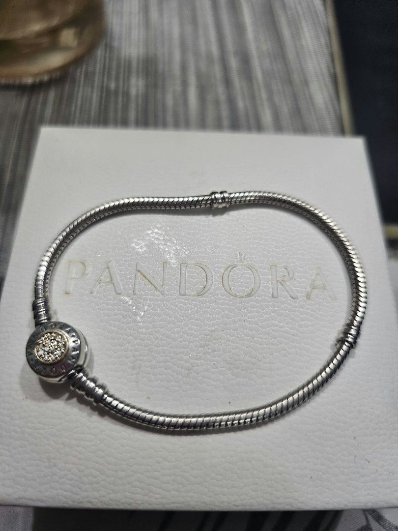 Pandora Silver Snake Chain Bracelet with Pave Clasp (Category: Bracelets) located in Makati City. Submitted by idaevangelista (Listing ID 1470884616, Image 1). Description: - Authentic Pandora silver snake chain bracelet - Features a round clasp with a gold-toned center and sparkling stones - Secure threaded barrel closure - Classic charm bracelet design with a clean metal finish - Includes original white branded box.
