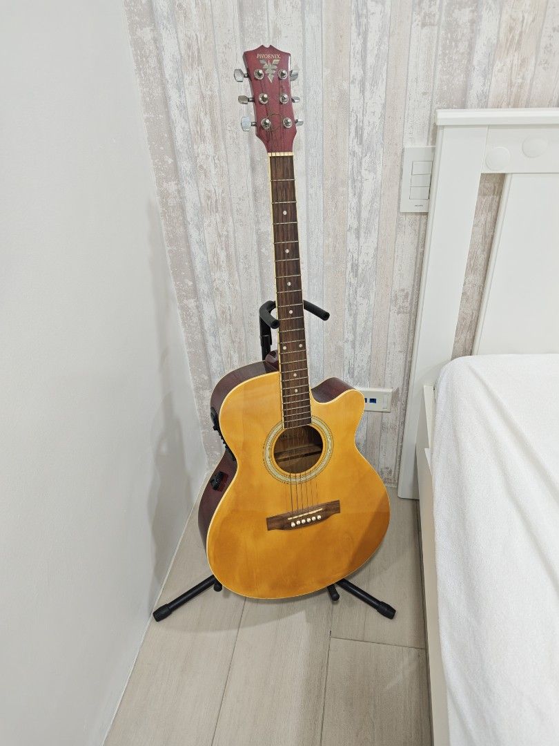 Phoenix CF-36 Acoustic Electric Guitar (Category: Musical Instruments) located in Makati City. Submitted by arkizx (Listing ID 1470807436, Image 1). Description: Phoenix CF-36 acoustic electric guitar with cutaway body. Built-in EQ-7545R preamp system with volume, bass, middle, treble, and presence sliders. Red headstock with metal tuning pegs, shows dust and some rust on the hardware. Natural wood finish body. One string is broken and wrapped ar