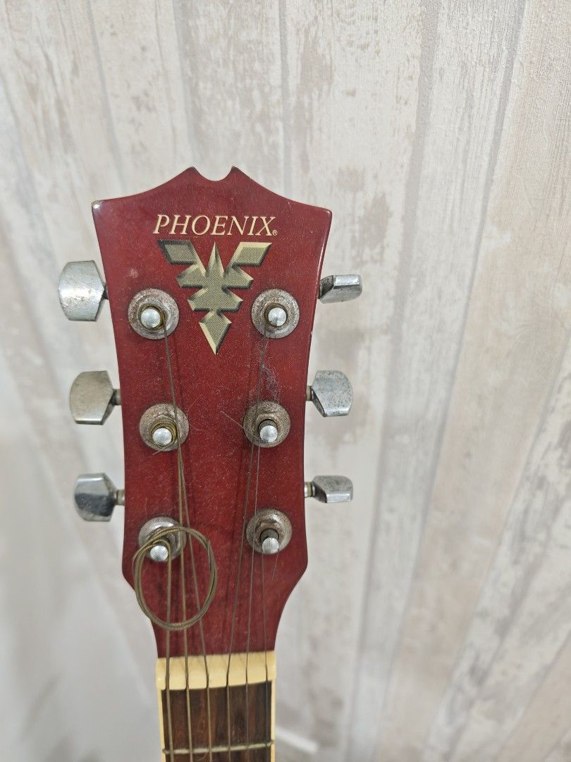 Phoenix CF-36 Acoustic Electric Guitar (Category: Musical Instruments) located in Makati City. Submitted by arkizx (Listing ID 1470807436, Image 3). Description: Phoenix CF-36 acoustic electric guitar with cutaway body. Built-in EQ-7545R preamp system with volume, bass, middle, treble, and presence sliders. Red headstock with metal tuning pegs, shows dust and some rust on the hardware. Natural wood finish body. One string is broken and wrapped ar