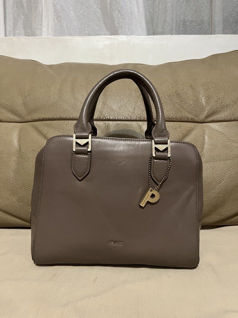 Picard Leather Satchel Handbag (Category: Luxury Bags & Wallets) located in Calamba. Submitted by jupreloved_ (Listing ID 1470792462, Image 1). Description: Picard taupe leather handbag with gold hardware. Features dual top handles, zip top closure, organized interior compartments, and a bonus back zip pocket. Brand: Picard Size: Medium Shipping through J&T. Payment are strictly through GCASH only, no COD. Exact size and color may be different fr
