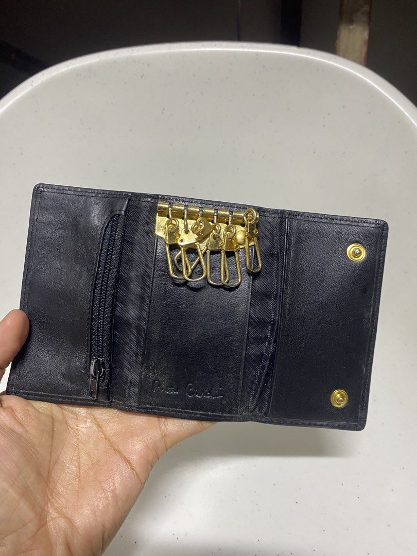 Pierre Cardin Black Leather Key Case Holder (Category: Wallets & Card holders) located in Pasacao. Submitted by wengpullar37205 (Listing ID 1470905454, Image 3). Description: - Brand: Pierre Cardin - Material: Genuine black leather with gold-tone hardware - Capacity: 6 interior key hooks - Closure: Secure snap button closure - Extra storage: Small interior zippered pocket - Details: Debossed interior logo and front exterior metal brand plaque - C