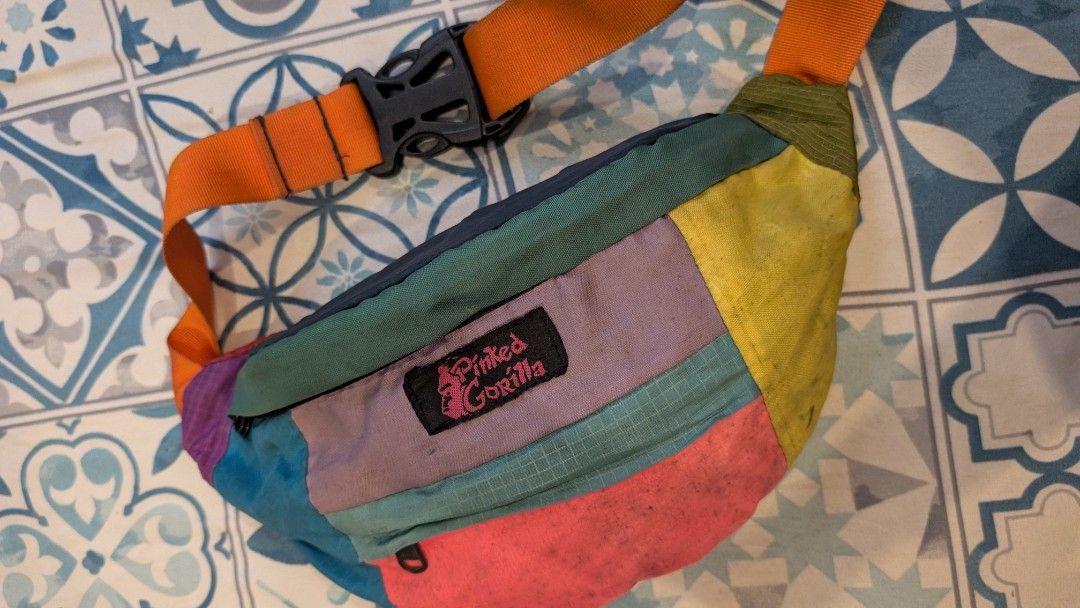 Pinked Gorilla Patchwork Fanny Pack Waist Bag (Category: Belt bags, Clutches and Pouches) located in Manila. Submitted by alypacis06 (Listing ID 1470764616, Image 1). Description: - Brand: Pinked Gorilla - Design: Multi-color patchwork in yellow, pink, blue, purple, and green - Strap: Adjustable orange strap with a sturdy black buckle - Pockets: Secure top zip closure, front pocket, and interior zippered compartments - Versatility: Can be worn cr