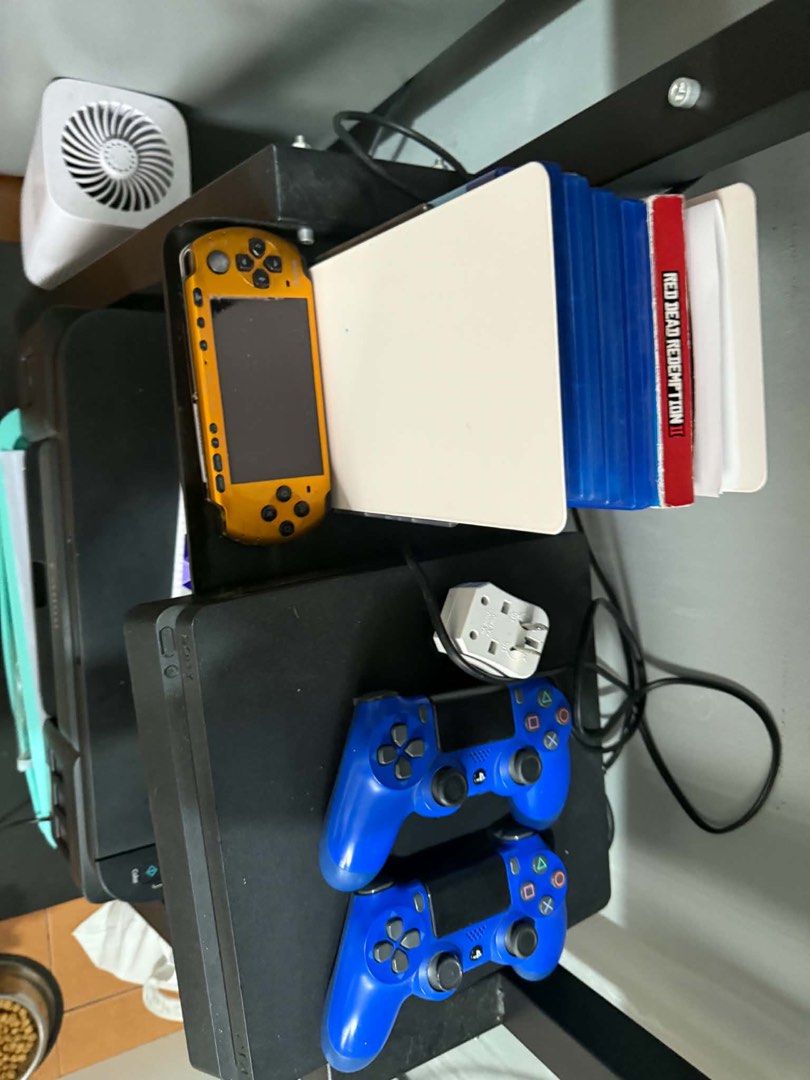 PlayStation 4 console with two controllers and games plus psp jb (Category: PlayStation) located in Manila. Submitted by fitibles (Listing ID 1470837262, Image 1). Description: - 2 matching blue controllers - PSP handheld included - Plug adapter included - 7 popular games: Red Dead Redemption II Special Edition, NBA 2K23, Horizon Zero Dawn, Resident Evil, Gear Shifters, Tekken, and God of War - Perfect all-in-one gaming bundle.
