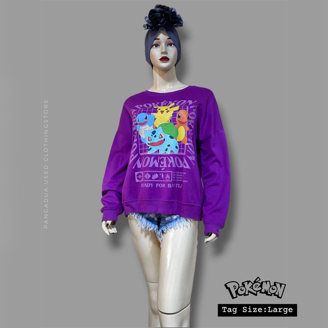 Pokémon Purple Graphic Sweatshirt Size L (Category: Coats, Jackets and Outerwear) located in Naga. Submitted by 2ndusedclothingstore (Listing ID 1470849643, Image 1). Description: - Purple Pokémon crewneck sweatshirt - Features Pikachu, Squirtle, Bulbasaur, and Charmander on the front - 'Ready For Battle' text graphic below the characters - Size: Large - Material: 62% polyester, 33% rayon, 5% spandex - Soft fleece interior texture - Machine wash 