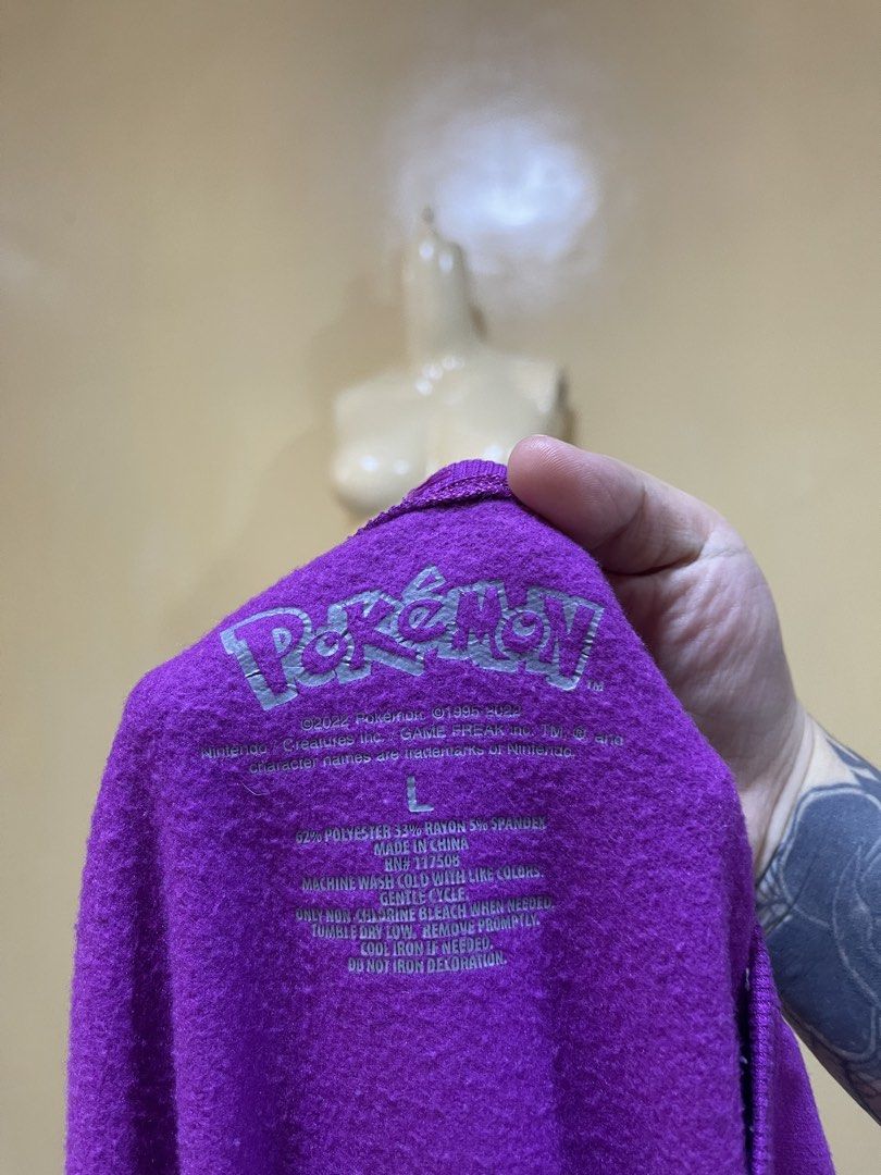 Pokémon Purple Graphic Sweatshirt Size L (Category: Coats, Jackets and Outerwear) located in Naga. Submitted by 2ndusedclothingstore (Listing ID 1470849643, Image 2). Description: - Purple Pokémon crewneck sweatshirt - Features Pikachu, Squirtle, Bulbasaur, and Charmander on the front - 'Ready For Battle' text graphic below the characters - Size: Large - Material: 62% polyester, 33% rayon, 5% spandex - Soft fleece interior texture - Machine wash 
