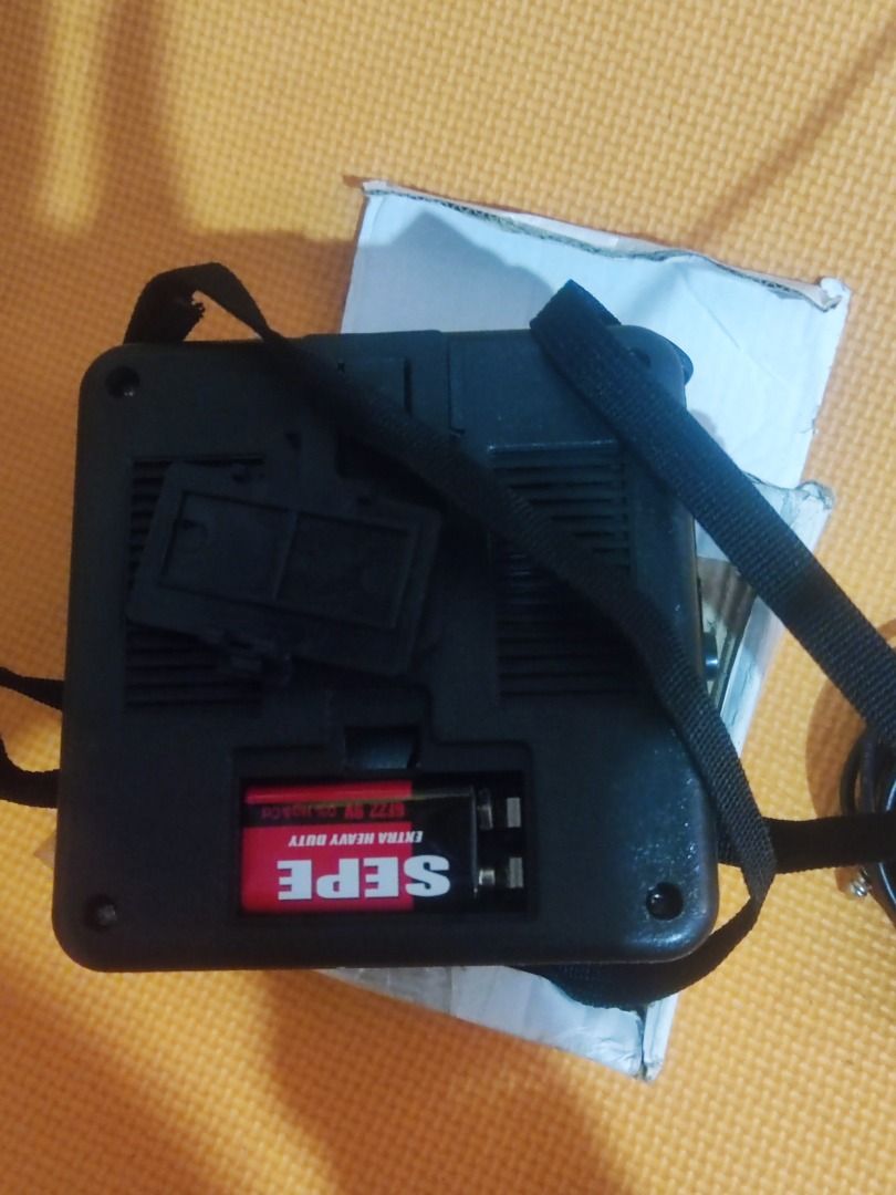 Portable Mini Amplifier with Strap and Battery (Category: Soundbars, Speakers & Amplifiers) located in Valenzuela. Submitted by reynoldyabut6536 (Listing ID 1470768114, Image 1). Description: Black portable mini amplifier 5watts unit with a carrying strap attached. Operates on a 9V SEPE battery, which is included inside the battery compartment. Open battery cover shown next to the slot. Plastic casing with vent grilles. Comes with a white cardboa