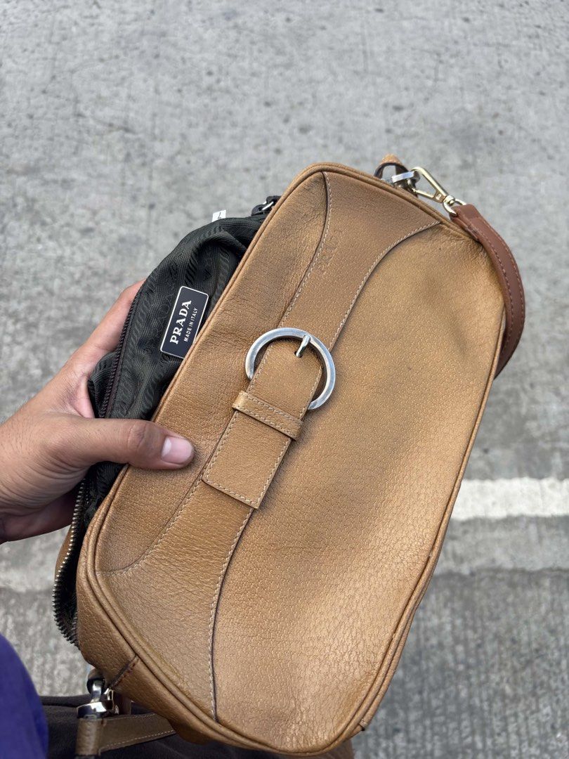 Prada Brown Leather Shoulder Bag with Buckle (Category: Luxury Bags & Wallets) located in General Santos City (Dadiangas). Submitted by rachelleclosets2026._gem (Listing ID 1470835113, Image 1). Description: - Authentic Prada shoulder bag in rich textured brown leather - Stylish silver hardware buckle detail on the front flap - Secure zip closure with durable fabric lining - Adjustable strap with metal clasps for a custom fit - Features 'Made in 