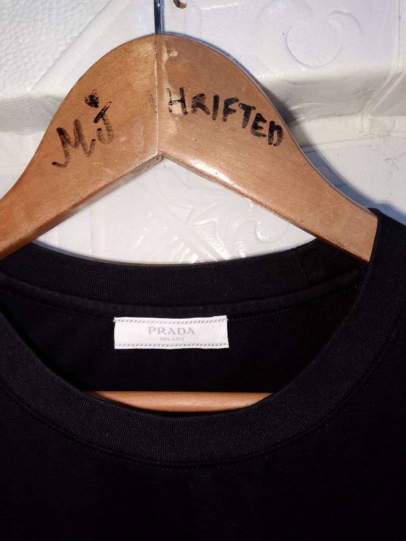 Prada Milano Black T-Shirt Size M (Category: Shirts) located in Manila. Submitted by mjthrifted_second (Listing ID 1470823934, Image 2). Description: - Brand: Prada Milano - Style: Crewneck short sleeve tee - Color: Solid black with blue embroidered chest logo - Size: Medium (Standard fit) -Dimes: 21/27 - Material: Premium cotton - Origin: Made in Italy - Authenticity: Interior neck label and wash tags intact (Style Code: UCS339) - Trusted Carous