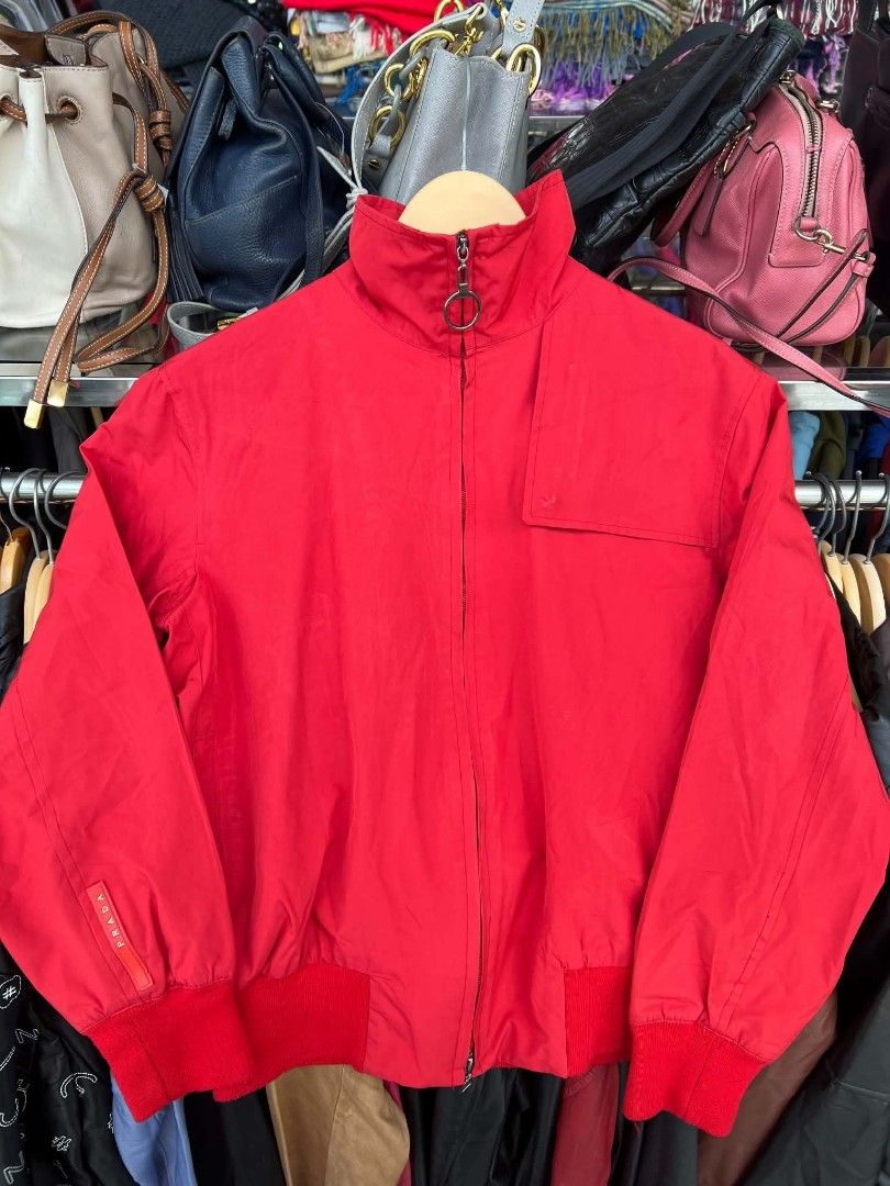 Prada Red Nylon Bomber Jacket Art.SGV126 (Category: Coats, Jackets and Outerwear) located in Urdaneta. Submitted by jayceegarage (Listing ID 1470882000, Image 1). Description: - Brand: Prada - Item: Nylon Bomber Jacket - Color: Red - Size: Medium - Material: 100% Polyester - Made in Italy - Design: Stand collar with ring zip, ribbed red cuffs and hem, branded red fabric tag on right sleeve - Interior: Printed logo mesh lining with patterned accen