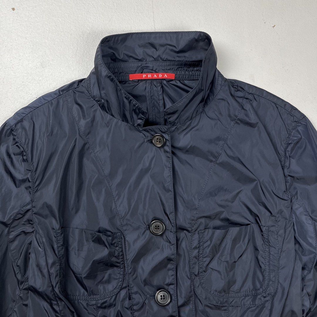 Prada Sport early 2000s nylon chore Jacket (Category: Luxury Apparel) located in Quezon City. Submitted by forgarments (Listing ID 1470831267, Image 3). Description: Prada Sport early 2000s nylon chore Jacket Excellent Condition - Sticky Care label Size: 40 Shoulder: 15.5 Inches Chest width: 17 Inches Waist: 15.5 Inches Sleeve: 19.5 Inches Length: 21 Inches - Convertible Collar & 4 Pocket set up - Sleeve cuffs & Red tab on right sleeve - Buttoned