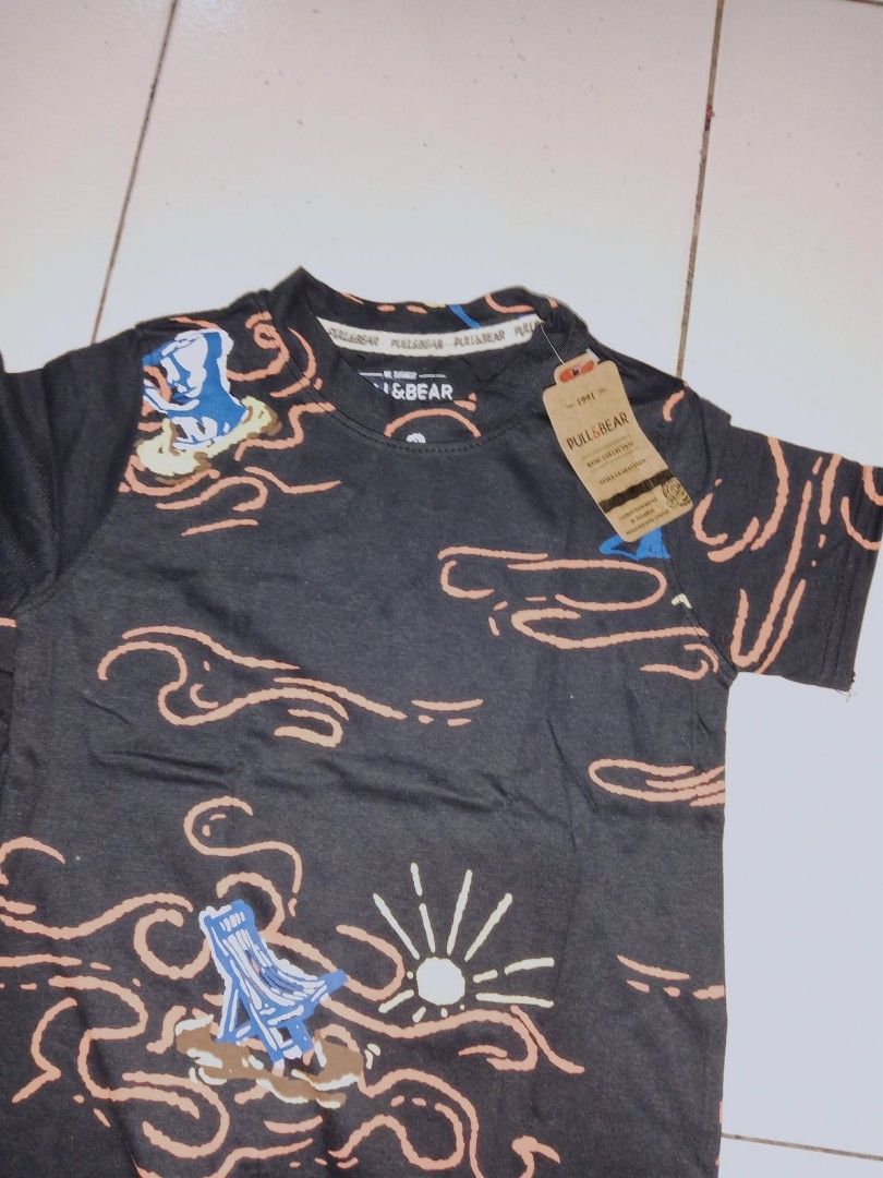 Pull&Bear Beach Doodle Graphic Tees (Overruns) (Category: Babies & Kids Fashion) located in Taguig. Submitted by iamyanggaragesale (Listing ID 1470743857, Image 3). Description: 🌊 Pull&Bear Beach Doodle Graphic Tees are now available. Loving the orange wave outlines and blue vacation graphics on this clean black base 🌴☀️ 💸 PRICING & BUNDLES: ▪️ 1 Piece: ₱180 ▪️ 2 Pieces: ₱350 (Save ₱10) ✨ Brand new with tags (High-quality overrun) 👕 Available