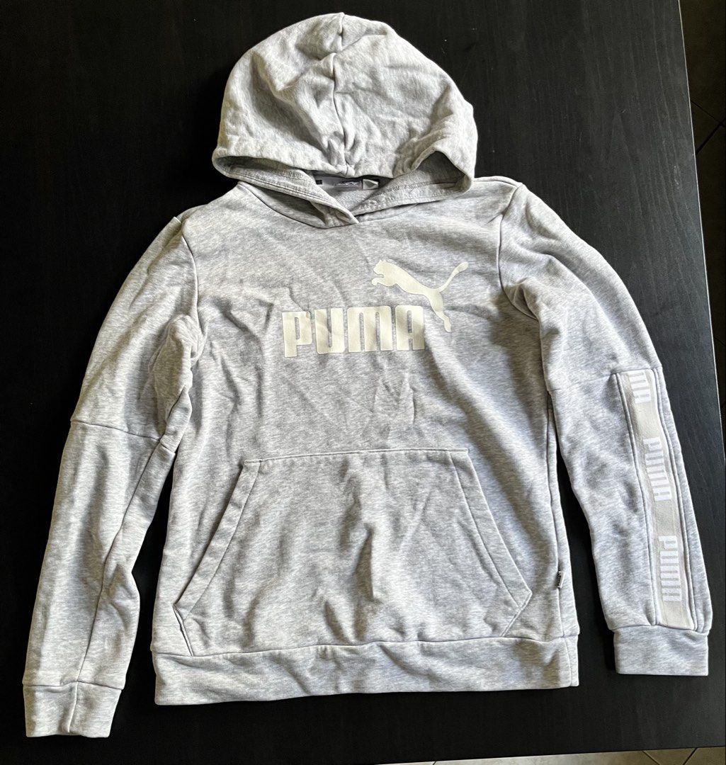 Puma Heather Grey Hoodie Sweatshirt Size S (Category: Hoodies) located in Manila. Submitted by sunshineapril (Listing ID 1470808421, Image 1). Description: - Brand: Puma - Size: Small - Color: Grey with white details - Material: Cotton blend fleece - Features: Front kangaroo pocket, ribbed cuffs and hem, large white Puma cat logo on chest - Accents: Matching white branded tape detail down the left sleeve - Condition: Good casual pullover for ever
