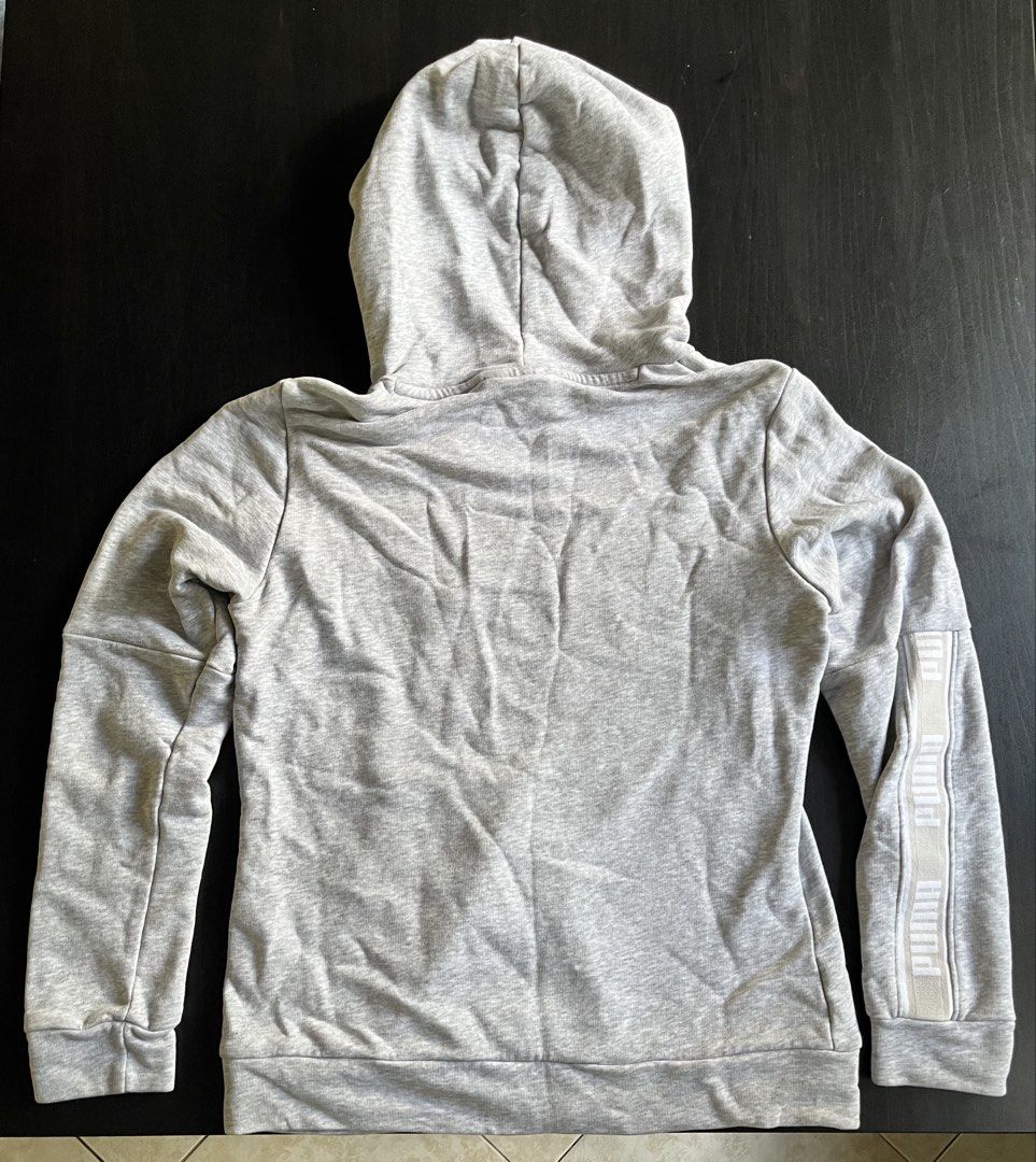 Puma Heather Grey Hoodie Sweatshirt Size S (Category: Hoodies) located in Manila. Submitted by sunshineapril (Listing ID 1470808421, Image 2). Description: - Brand: Puma - Size: Small - Color: Grey with white details - Material: Cotton blend fleece - Features: Front kangaroo pocket, ribbed cuffs and hem, large white Puma cat logo on chest - Accents: Matching white branded tape detail down the left sleeve - Condition: Good casual pullover for ever