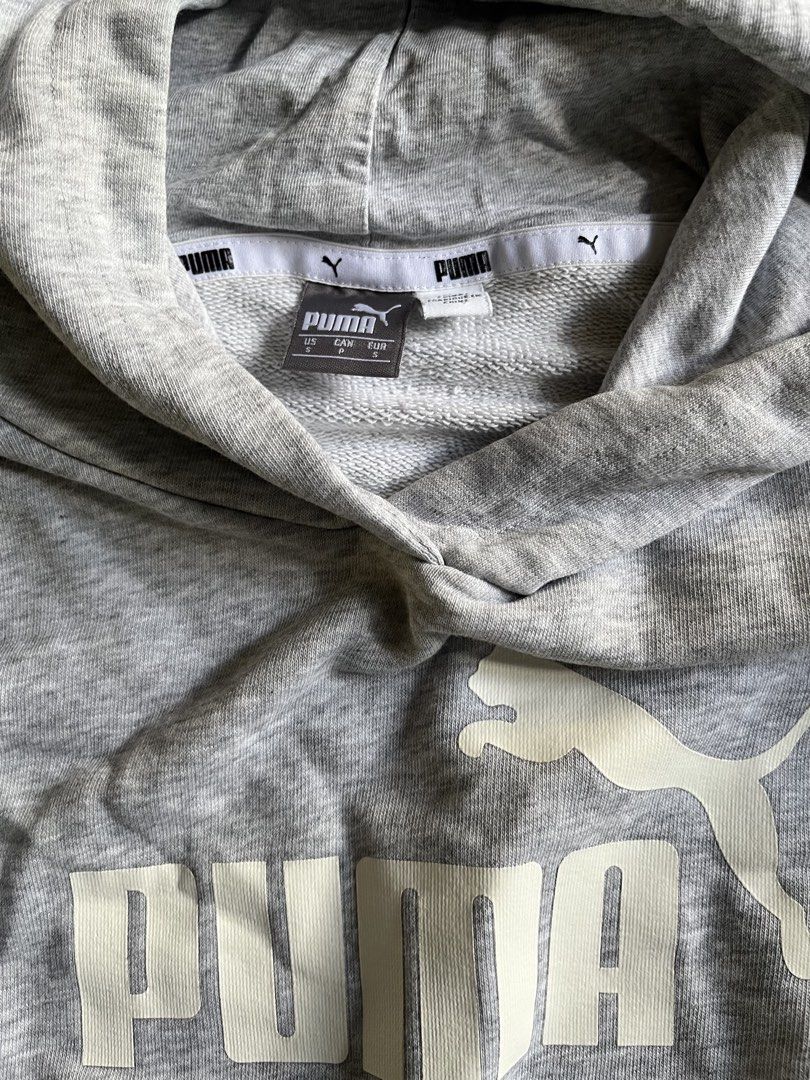Puma Heather Grey Hoodie Sweatshirt Size S (Category: Hoodies) located in Manila. Submitted by sunshineapril (Listing ID 1470808421, Image 3). Description: - Brand: Puma - Size: Small - Color: Grey with white details - Material: Cotton blend fleece - Features: Front kangaroo pocket, ribbed cuffs and hem, large white Puma cat logo on chest - Accents: Matching white branded tape detail down the left sleeve - Condition: Good casual pullover for ever