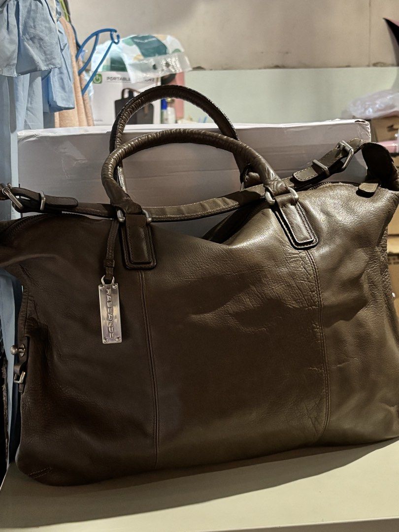 Rabeanco Brown Leather Shoulder Bag (Category: Luxury Bags & Wallets) located in Rizal. Submitted by va_nes_sa_ (Listing ID 1470818261, Image 1). Description: - Authentic Rabeanco leather shoulder bag in greenish brown - Spacious main compartment with secure top zip closure - Sturdy dual handles and a versatile adjustable shoulder strap - Features signature metal brand charm on the front - Interior fabric lining with a convenient zippered pocket 