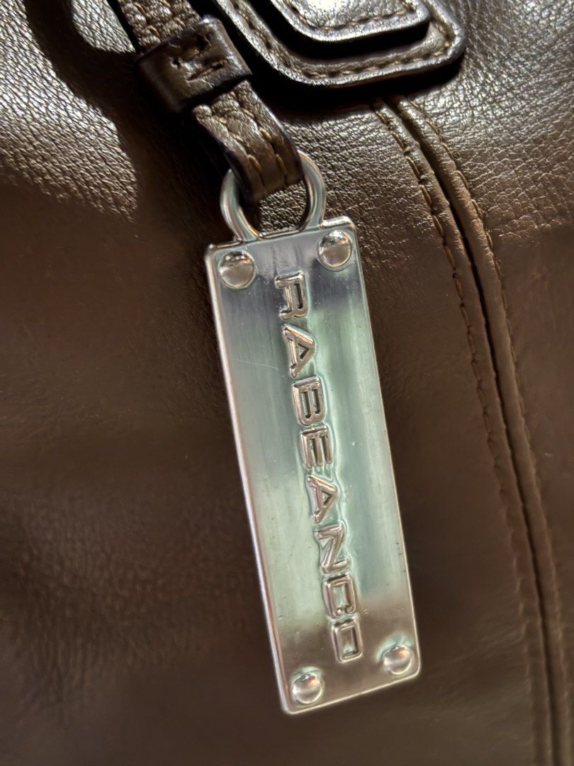 Rabeanco Brown Leather Shoulder Bag (Category: Luxury Bags & Wallets) located in Rizal. Submitted by va_nes_sa_ (Listing ID 1470818261, Image 3). Description: - Authentic Rabeanco leather shoulder bag in greenish brown - Spacious main compartment with secure top zip closure - Sturdy dual handles and a versatile adjustable shoulder strap - Features signature metal brand charm on the front - Interior fabric lining with a convenient zippered pocket 