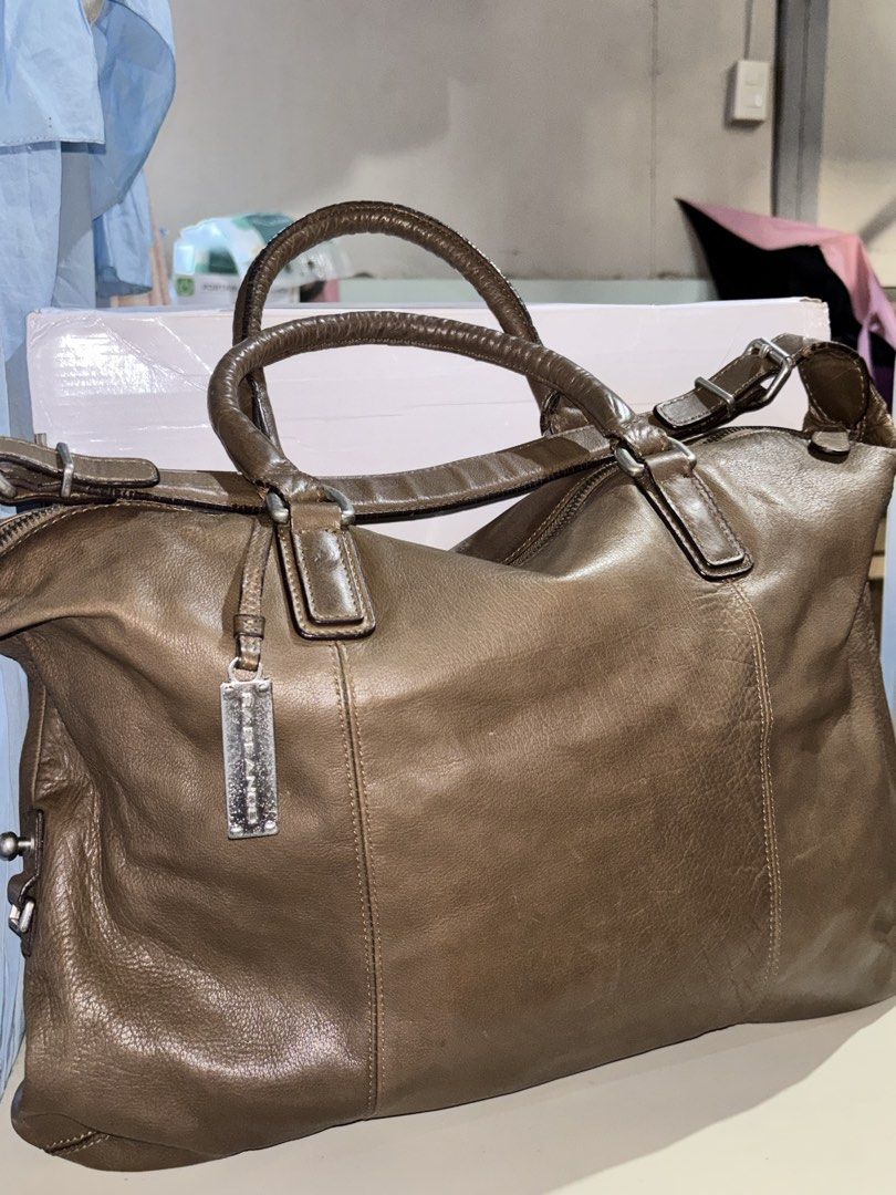 Rabeanco Brown Leather Shoulder Bag (Category: Luxury Bags & Wallets) located in Rizal. Submitted by va_nes_sa_ (Listing ID 1470818261, Image 2). Description: - Authentic Rabeanco leather shoulder bag in greenish brown - Spacious main compartment with secure top zip closure - Sturdy dual handles and a versatile adjustable shoulder strap - Features signature metal brand charm on the front - Interior fabric lining with a convenient zippered pocket 