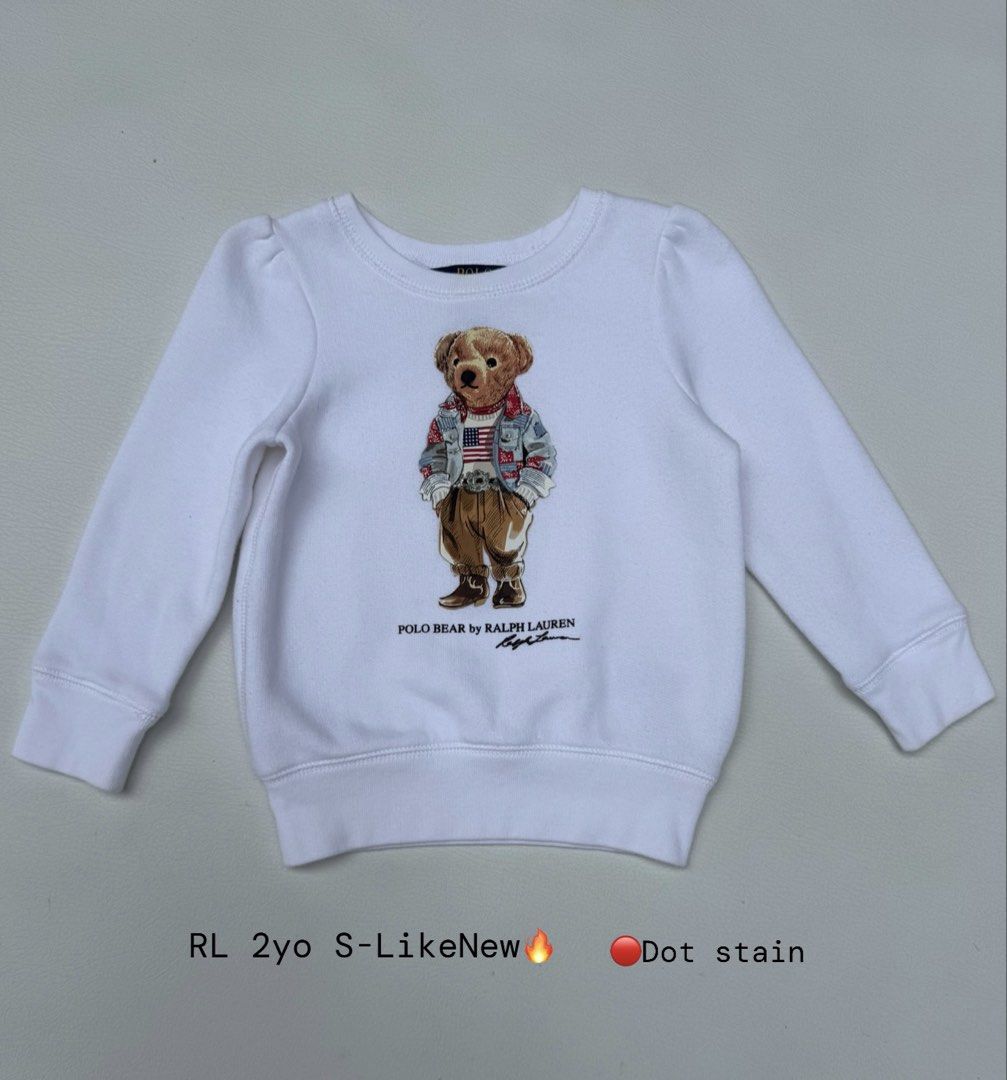 Ralph Lauren Polo Bear Sweatshirt 2yo (Category: Babies & Kids Fashion) located in Pozorrubio. Submitted by izaykite2g (Listing ID 1470762068, Image 1). Description: - Brand: Ralph Lauren - Size: 2 Years Old - Color: White - Design: Iconic Polo Bear graphic (wearing denim jacket and flag sweater) - Material: Soft fleece interior for extra warmth - Details: Long sleeves, classic crew neckline, ribbed cuffs and hem - Flaw: Small dot stain near the 