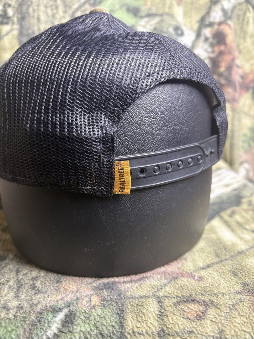 Realtree trucker Cap (Category: Caps & Hats) located in Manila. Submitted by josh2295 (Listing ID 1470757620, Image 3). Description: Realtree camo hunting and trucker-style baseball cap featuring a brown leather-look patch on the front and a Canadian flag patch on the side..