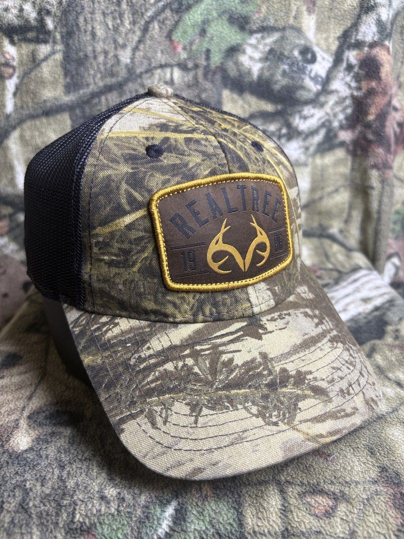 Realtree trucker Cap (Category: Caps & Hats) located in Manila. Submitted by josh2295 (Listing ID 1470757620, Image 1). Description: Realtree camo hunting and trucker-style baseball cap featuring a brown leather-look patch on the front and a Canadian flag patch on the side..