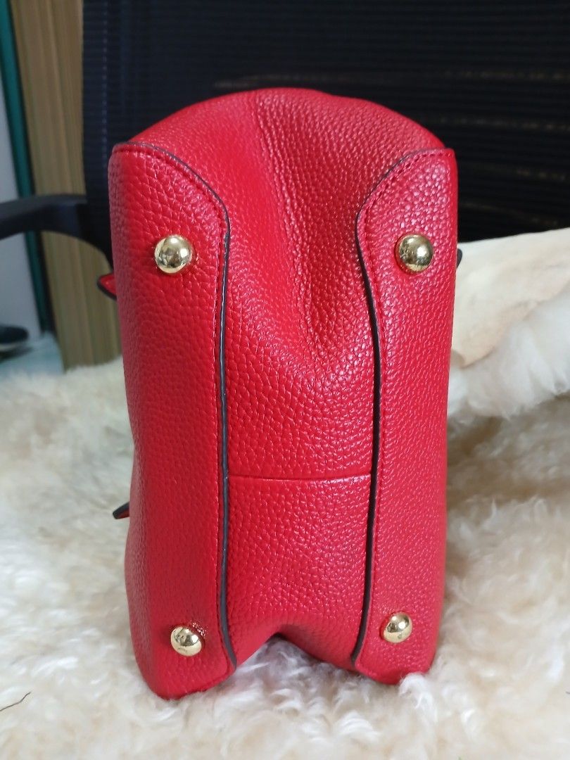 Red Leather Handbag Tote Bucket Bag (Category: Tote Bags) located in Taguig. Submitted by demsclosetph (Listing ID 1470796717, Image 2). Description: - Color & Material: Bright red pebble-grain - Design: Structured bucket shape with top handles and 'H' logo - Hardware: Gold-tone protective feet at the bottom - Interior: Brown lining with snap button closures and side compartments - Condition: Clean inside and out, sturdy construction.