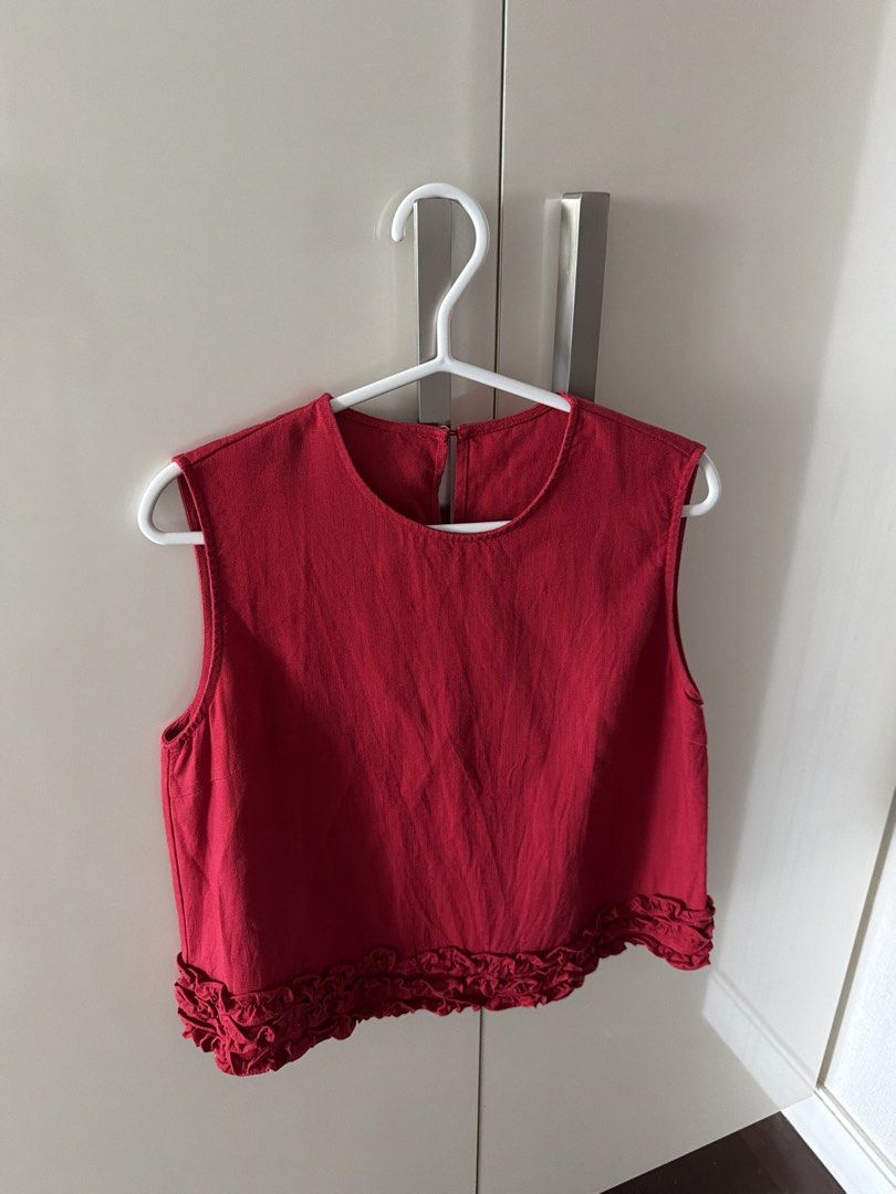 Red Sleeveless Crop Top with Ruffle Hem (Category: Sleeveless) located in Manila. Submitted by shopwt.anna (Listing ID 1470819480, Image 1). Description: - Color: Bright red - Style: Sleeveless cropped top with a cute ruffled hem - Material: Textured linen-like fabric - Details: Round neckline with a back button keyhole closure - Condition: Clean and ready to wear - Perfect to pair with high-waisted jeans or skirts for casual days.