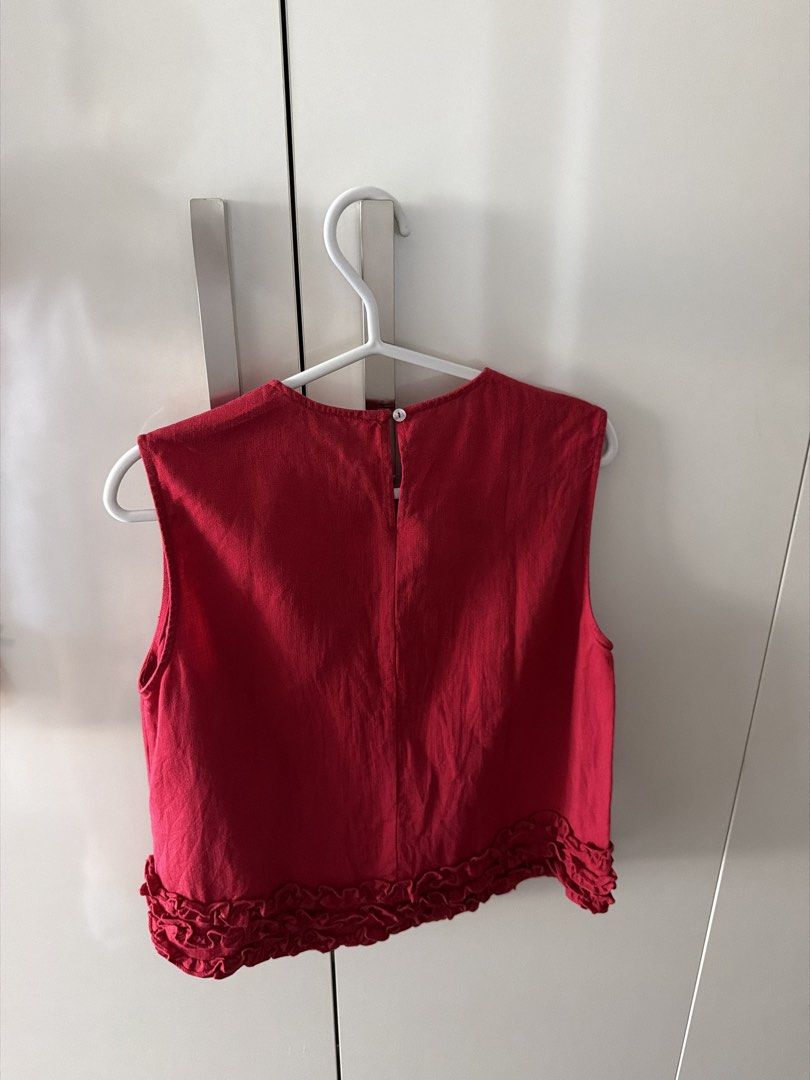 Red Sleeveless Crop Top with Ruffle Hem (Category: Sleeveless) located in Manila. Submitted by shopwt.anna (Listing ID 1470819480, Image 3). Description: - Color: Bright red - Style: Sleeveless cropped top with a cute ruffled hem - Material: Textured linen-like fabric - Details: Round neckline with a back button keyhole closure - Condition: Clean and ready to wear - Perfect to pair with high-waisted jeans or skirts for casual days.
