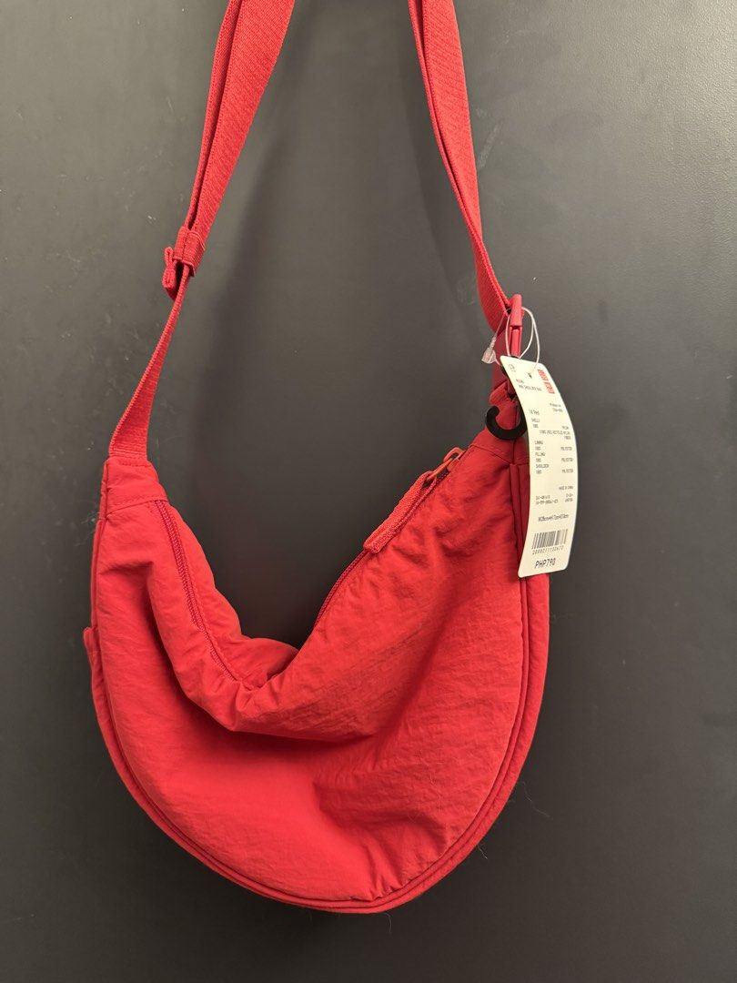 Red Uniqlo Round Mini Shoulder Bag (Category: Cross-body Bags) located in Makati City. Submitted by 099baby (Listing ID 1470876298, Image 1). Description: Brand new Uniqlo Round Mini Shoulder Bag in Red with original tags. Made of durable nylon with a zipper, adjustable strap, and interior pockets. Dimensions: W 28cm x H 17cm x D 10cm. Brand new with tags.