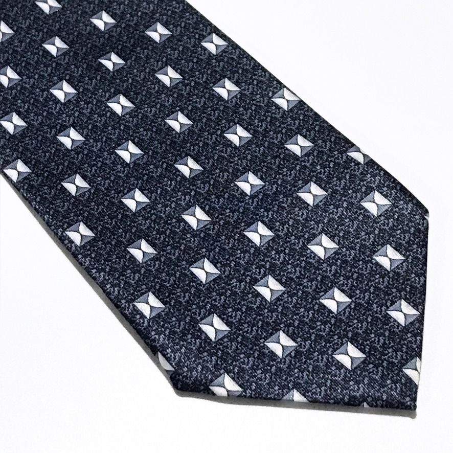 Rene Chagal Geometric Pattern Slate Blue Neck Tie (Category: Ties) located in Taguig. Submitted by retrogaze (Listing ID 1470851142, Image 2). Description: This necktie by Rene Chagal features a slate blue ground with a subtle, stippled micro-pattern. The body is decorated with an orderly geometric foulard pattern of small, square bowtie-like motifs rendered in crisp white, light grey, and charcoal accents. Recommended Suit & Shirt Pairings: • Th