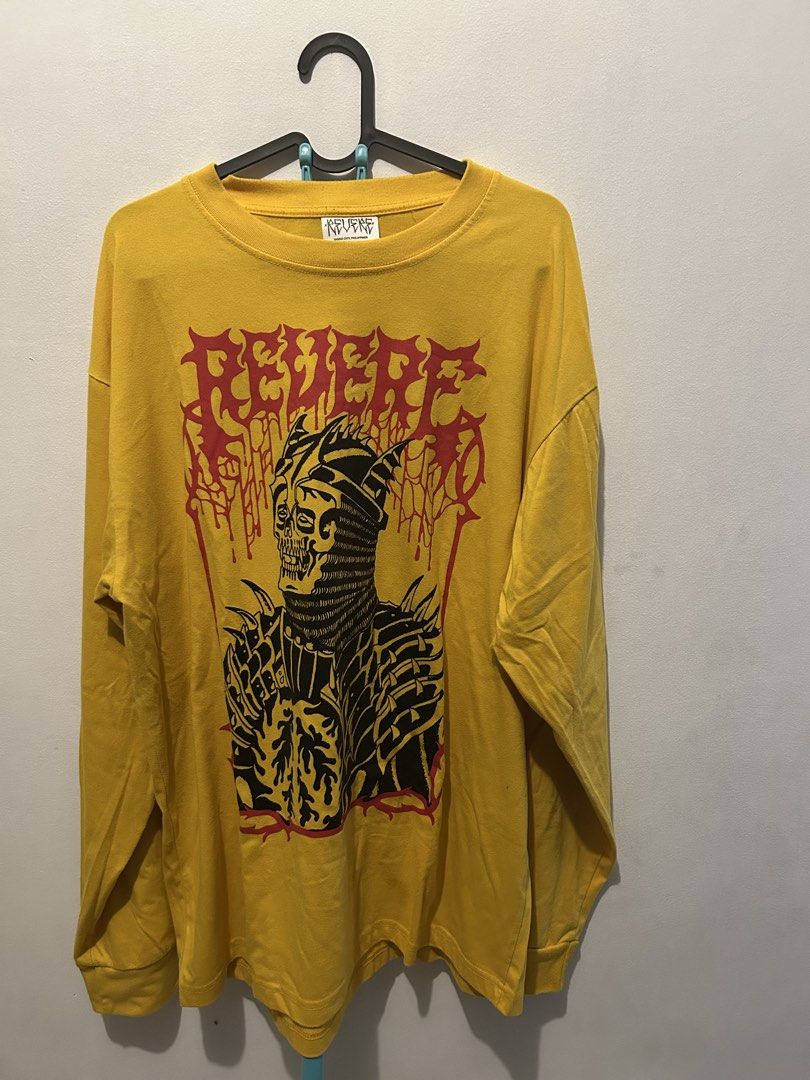 Revere Long Sleeve (Category: Tshirts & Polo Shirts ) located in Makati City. Submitted by kengs_ (Listing ID 1470767873, Image 1). Description: - Brand: Revere - Color: Bright yellow with black and red graphic - Design: Large medieval knight skeleton print with matching red lettering - Material: Heavy cotton, regular fit - Details: Crew neck collar, neckline tag - Style: Standout streetwear piece with vibrant colors.