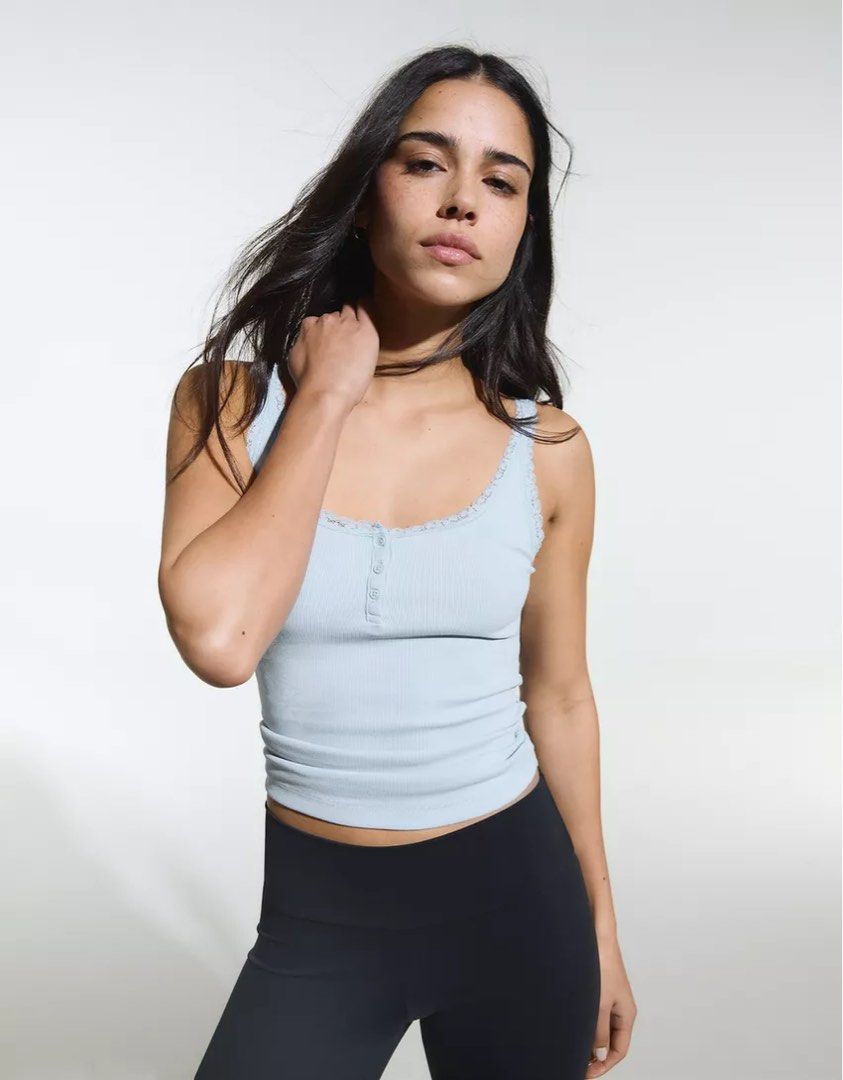 Ribbed lace trim cami tank top (Category: Sleeveless) located in Manila. Submitted by mnlclaudia (Listing ID 1470790381, Image 3). Description: - Color: Light blue - Material: Soft, stretchy cotton - Features: Delicate lace trim on scoop neckline and straps, functional front buttons - Fit: Body-hugging - Styling: Great for layering or wearing solo with jeans, skirts, or leggings.