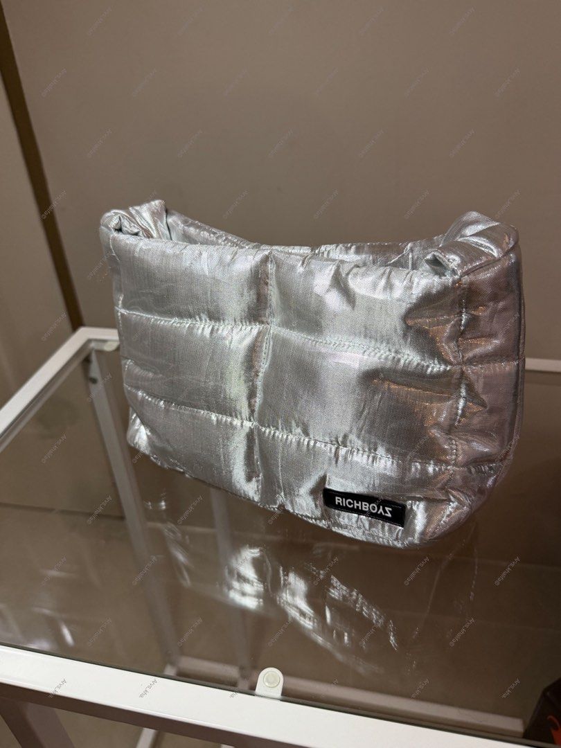 Richboyz Pufferino Bag Silver (Category: Shoulder Bags) located in Rosario. Submitted by chippycoco (Listing ID 1470766990, Image 2). Description: - Brand/Model: Richboyz Pufferino Bag - Color: Silver with a trendy metallic finish - Design: Quilted puffy style with bottom corner brand label - Features: Super lightweight material and a comfortable long strap - Condition/Status: Hard-to-find and currently sold out online.