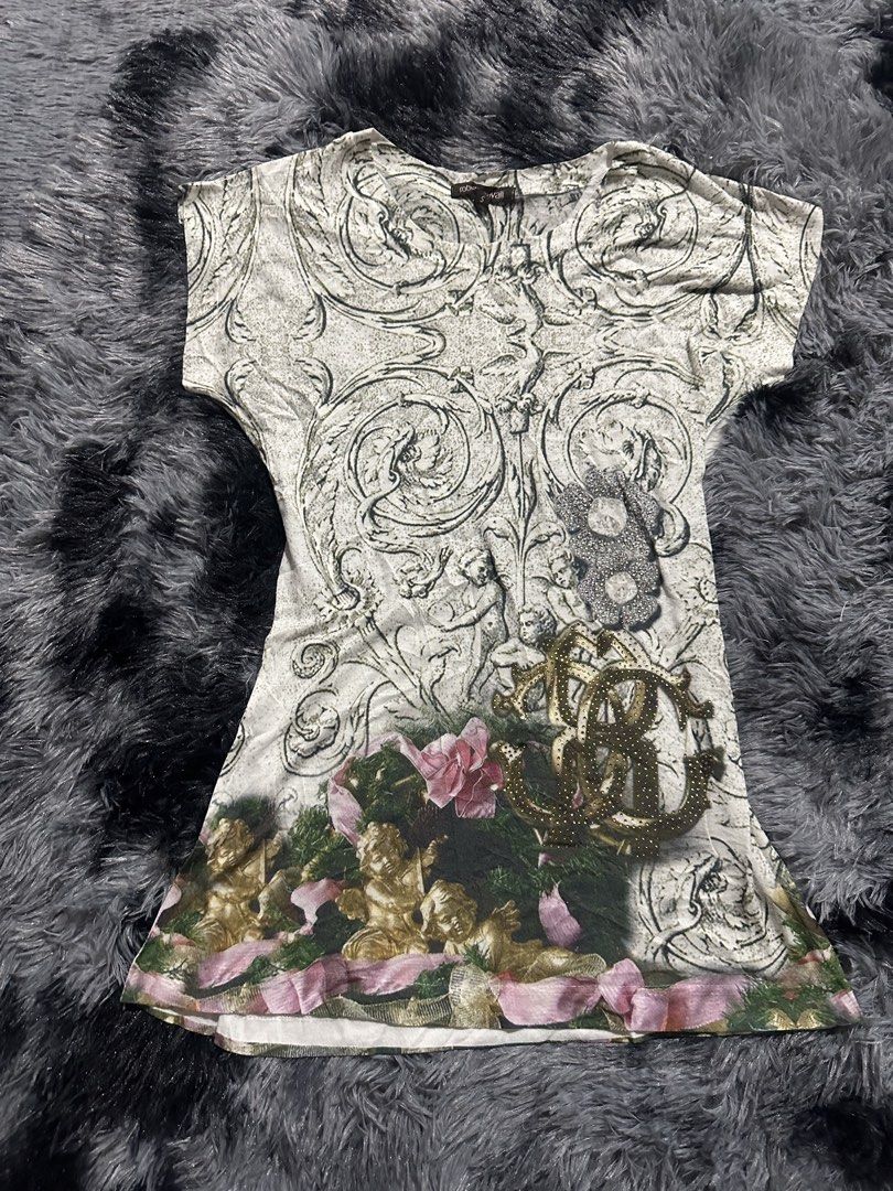 Roberto Cavalli Baroque Cherub Print Top Size S (Category: Shirts) located in Iba. Submitted by thriftcoyan (Listing ID 1470743555, Image 2). Description: - Brand: Roberto Cavalli - Size: Small - Design: Vintage Renaissance baroque scrollwork with cherubs and roses - Details: Front gold studded RC logo graphic and rhinestone floral appliques - Cut: Short cap sleeves with a classic round neckline - Material: Soft, stretchy, and comfortable fabric.