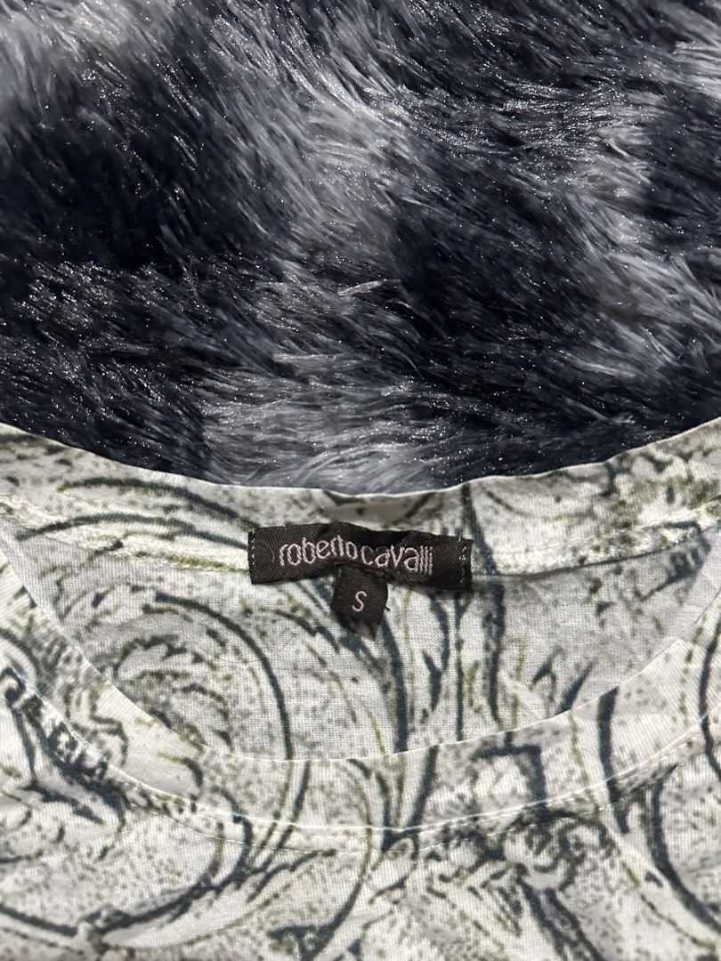 Roberto Cavalli Baroque Cherub Print Top Size S (Category: Shirts) located in Iba. Submitted by thriftcoyan (Listing ID 1470743555, Image 3). Description: - Brand: Roberto Cavalli - Size: Small - Design: Vintage Renaissance baroque scrollwork with cherubs and roses - Details: Front gold studded RC logo graphic and rhinestone floral appliques - Cut: Short cap sleeves with a classic round neckline - Material: Soft, stretchy, and comfortable fabric.