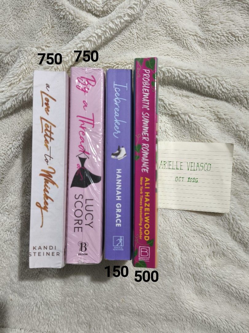 Romance Novels (Category: Storybooks) located in Abucay. Submitted by booksbyjie (Listing ID 1470816268, Image 1). Description: - Romance Novel Collection available individually or as a bundle - A Love Letter to Whiskey by Kandi Steiner (Brand New)- ₱750 - By a Thread by Lucy Score (Brand new) - ₱750 - Icebreaker by Hannah Grace - ₱150 - Problematic Summer Romance by Ali Hazelwood - ₱500 - Individual prices marked on the spine photo - Perfect rea